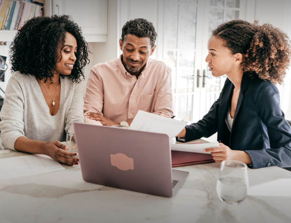 two women and a man looking at a computer reviewing their life insurance