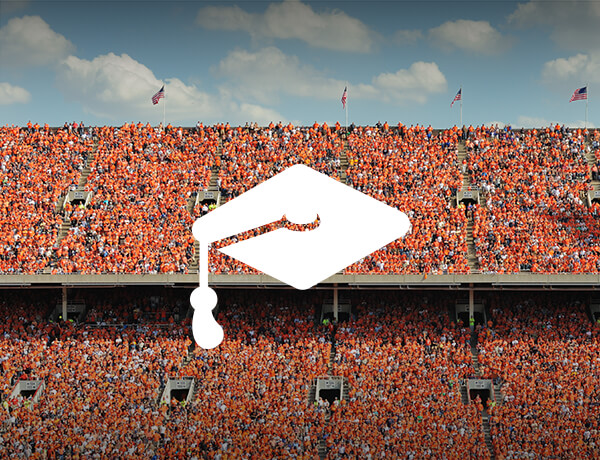 stadium of students at a college stadium with a graduation cap icon on top