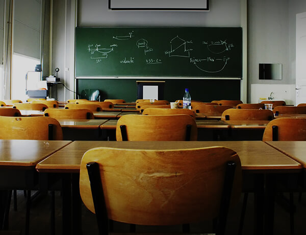 a classroom full of empty desks and a chalk board